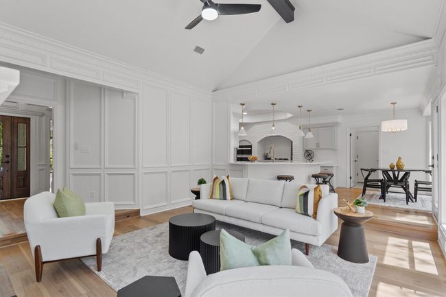 Living area with a decorative wall, light wood-type flooring, beam ceiling, high vaulted ceiling, and ceiling fan | Image 6