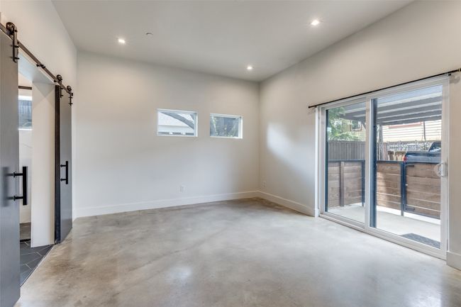 Unfurnished room featuring a barn door, healthy amount of natural light, concrete flooring, and recessed lighting | Image 10