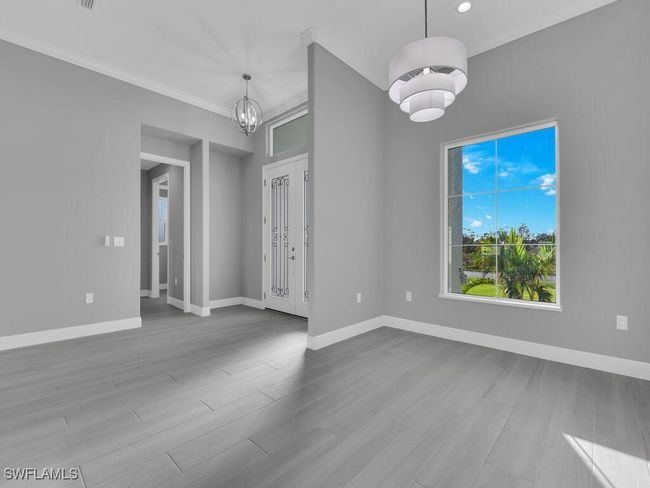 Spare room with a chandelier, wood finished floors, ornamental molding, and recessed lighting | Image 16