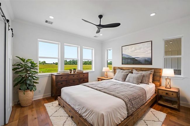 Spacious and inviting primary bedroom with abundant natural light, showcasing elegant furnishings and serene views. Perfect for relaxation and comfort. DIGITALLY STAGED | Image 22