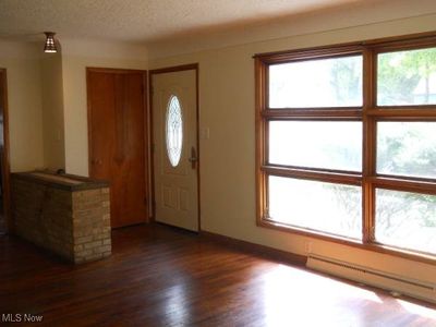 Entrance foyer with a baseboard heating unit, dark hardwood / wood-style flooring, and a textured ceiling | Image 2