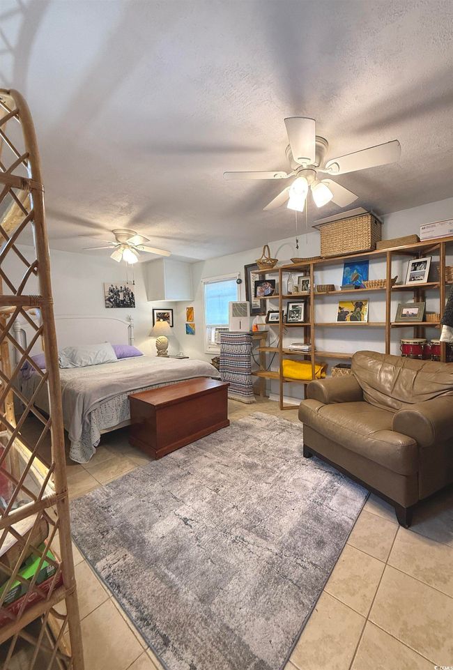 Bedroom featuring light tile patterned floors, a textured ceiling, and a ceiling fan | Image 21