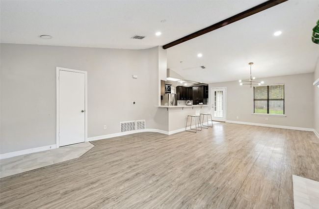 This is an angle of the entryway with beautiful tile floors flowing into luxury vinyl plank flooring and this home has a coat closet immediately to your left upon walking in, perfect for extra storage. | Image 5