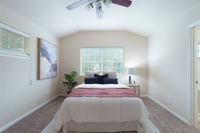 Bedroom featuring ceiling fan, baseboards, vaulted ceiling, and carpet | Image 8