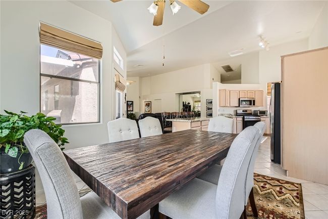 Dining room featuring light tile patterned flooring, ceiling fan, and high vaulted ceiling | Image 14