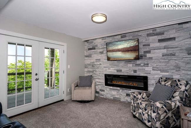 Lower level family room with quartz wall and cool fireplace. | Image 17