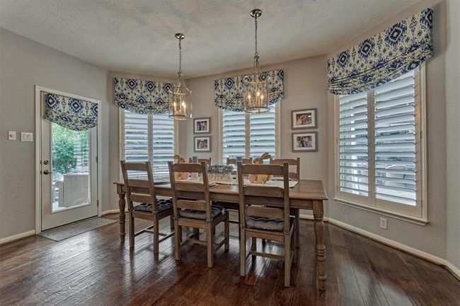 Generous Breakfast area accommodates family and friends with windows overlooking backyard. Door on left allows easy access to pool and outdoor area. | Image 21