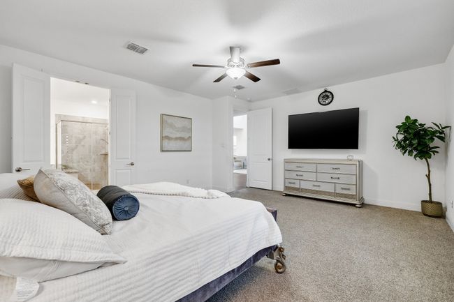 Carpeted bedroom with ceiling fan and ensuite bathroom | Image 10