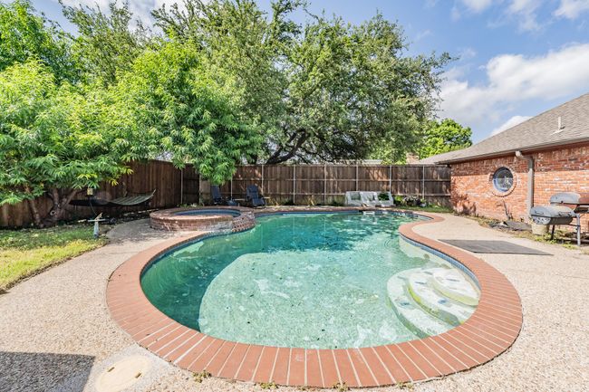 View of pool featuring a fenced backyard, grilling area, and a pool with connected hot tub | Image 22