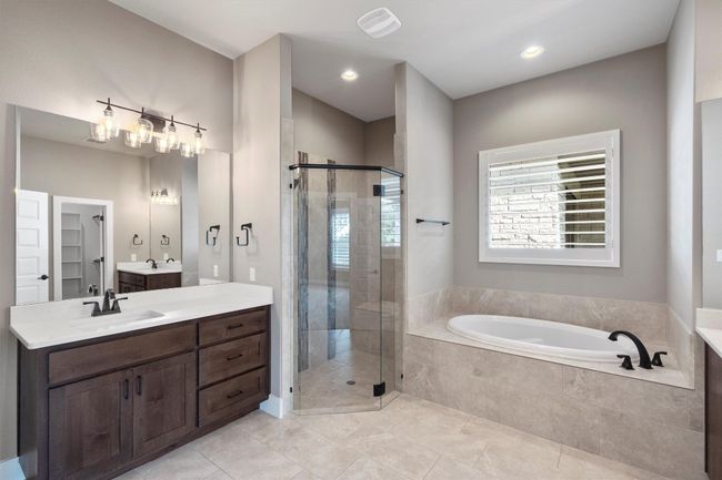 Bathroom with a shower stall, a bath, tile patterned flooring, vanity, and recessed lighting | Image 14