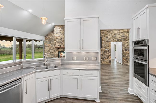 Kitchen with pendant lighting, white cabinets, sink, dark hardwood / wood-style floors, and stainless steel appliances | Image 27