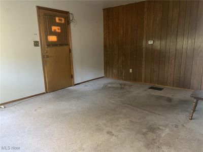 Carpeted spare room with wooden walls | Image 3