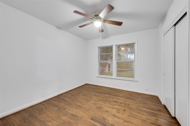 Unfurnished bedroom with baseboards, wood finished floors, a closet, and ceiling fan | Image 10