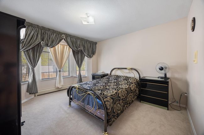 Bedroom featuring baseboards, a baseboard heating unit, and carpet floors | Image 24