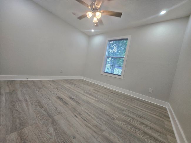 Empty room with wood finished floors, ceiling fan, and recessed lighting | Image 13