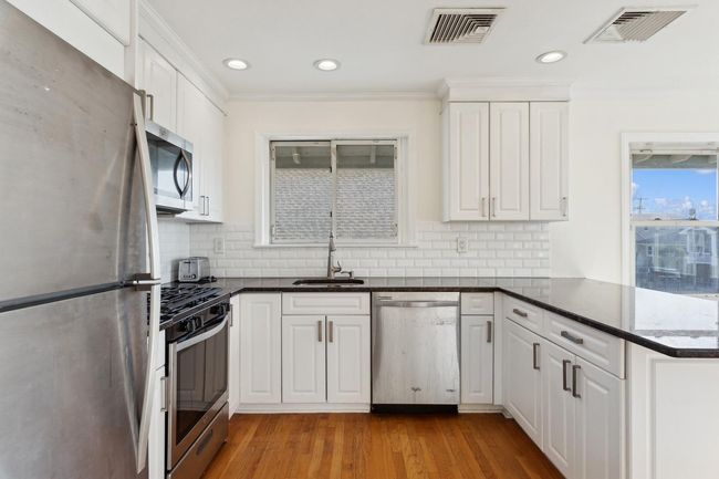 Kitchen featuring a peninsula, visible vents, stainless steel appliances, and a sink | Image 11