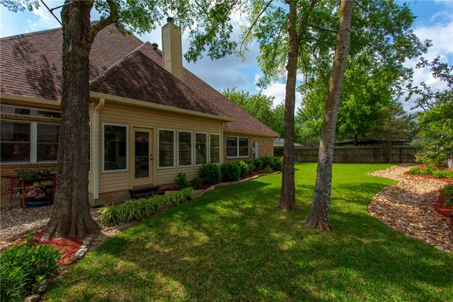 Back of property featuring a chimney, fence, a yard, and a shingled roof | Image 36