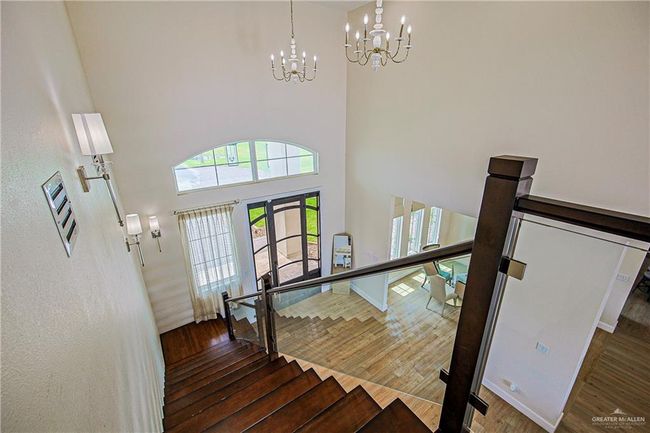 Stairs featuring a chandelier, porcelain floors, french doors, and a high ceiling | Image 13