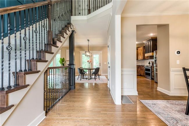 Entrance foyer with crown molding, light wood-style flooring, stairway, and wainscoting | Image 4