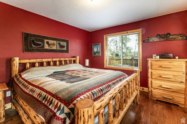 Bedroom with dark wood-style flooring and baseboards | Image 18