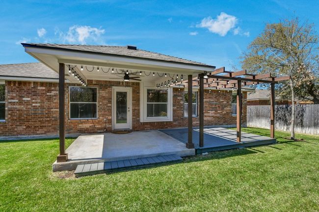 Outdoor living at it's finest! Expanded covered patio and deck with updated ceiling fan. Note the beautiful lawn! This home is four sides masonry! | Image 21