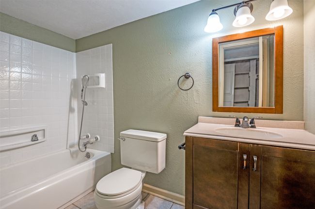 Bathroom with vanity, bathtub / shower combination, and tile patterned flooring | Image 12