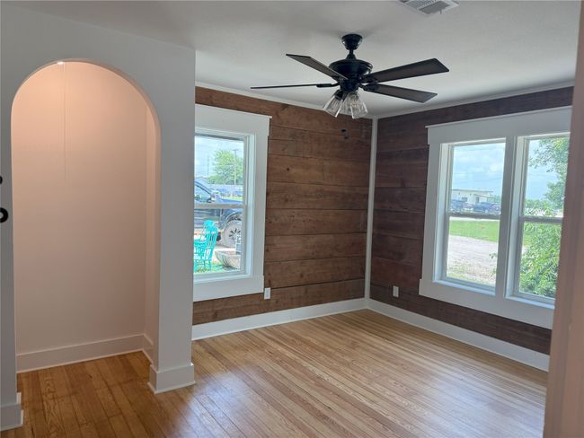 Spare room featuring light wood-style floors, wood walls, and ceiling fan | Image 30