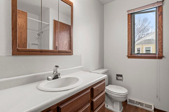 The main-level full bathroom features a tub/shower combo, a spacious linen closet, LVP flooring, and a single vanity with ample storage. | Image 8