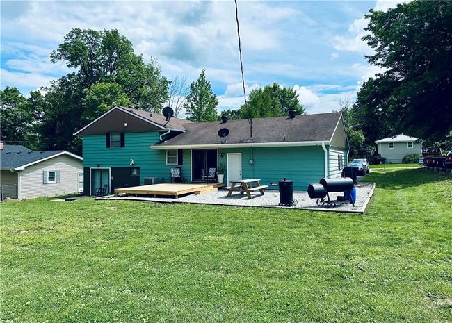 Back of house featuring a deck, a yard, a patio, and a shingled roof | Image 24
