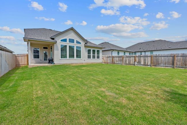 Back of property with a fenced backyard, roof with shingles, a yard, and a patio | Image 4