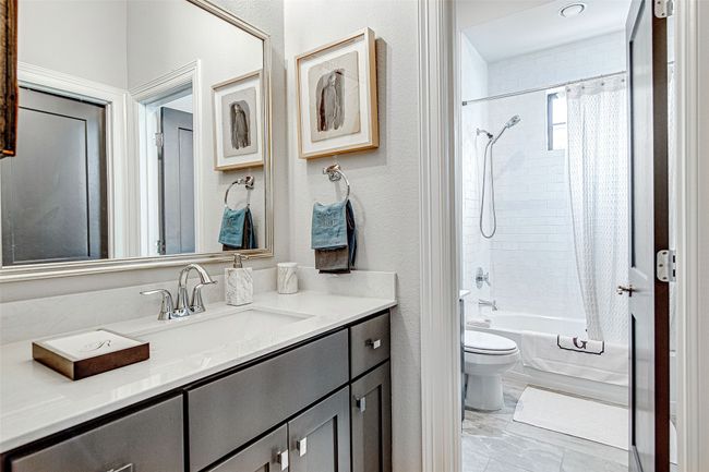Full bath featuring a textured wall, shower / bath combo with shower curtain, vanity, and toilet | Image 29