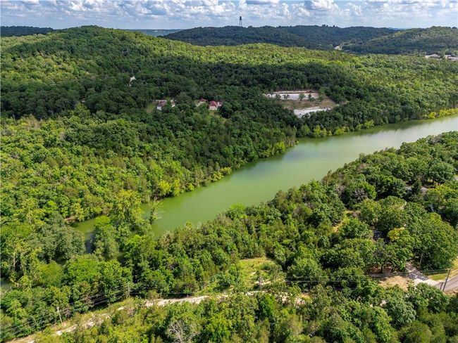 Aerial overview of property's location with a forest and a nearby body of water | Image 13