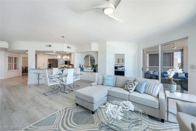 Living room featuring ceiling fan with notable chandelier and light hardwood / wood-style floors | Image 3