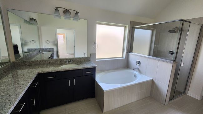 Bathroom with a shower stall, tile patterned flooring, a garden tub, vanity, and vaulted ceiling | Image 23