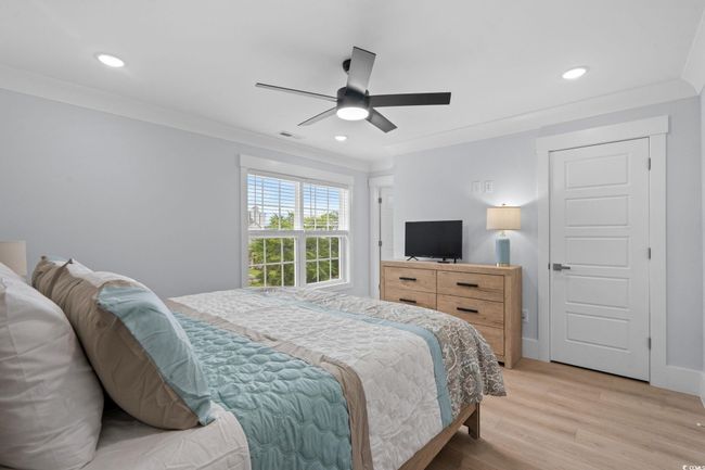 Bedroom with light wood-type flooring, crown molding, recessed lighting, and a ceiling fan | Image 29
