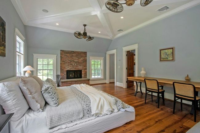 Bedroom featuring a chandelier, multiple windows, wood finished floors, a fireplace, and recessed lighting | Image 19