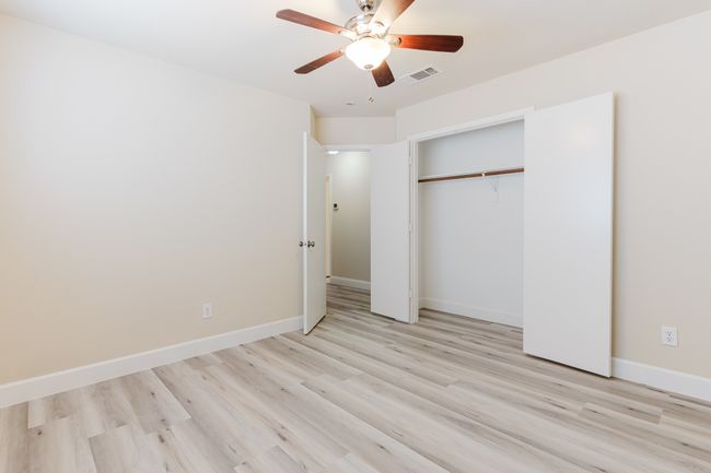 Unfurnished bedroom with light wood finished floors, visible vents, baseboards, a ceiling fan, and a closet | Image 16