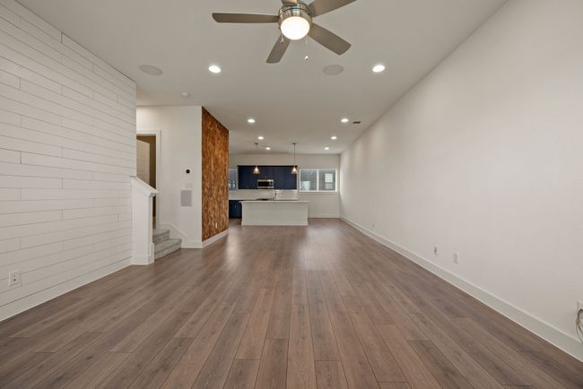 Unfurnished living room featuring baseboards, recessed lighting, stairway, ceiling fan, and dark wood-type flooring | Image 12