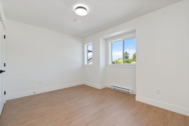 Unfurnished room featuring a baseboard heating unit and light wood-style floors | Image 26