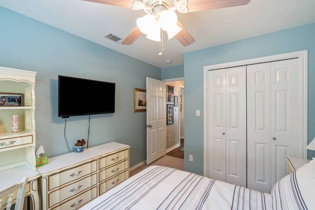 Carpeted bedroom featuring ceiling fan, baseboards, visible vents, and a closet | Image 16
