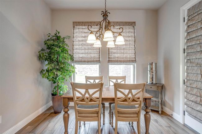 Dining space featuring a chandelier and wood finished floors | Image 18
