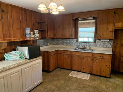 Kitchen with pendant lighting, a notable chandelier, tasteful backsplash, and sink | Image 3