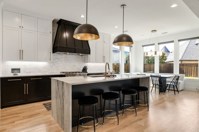 Kitchen featuring custom exhaust hood, backsplash, a sink, light wood finished floors, and recessed lighting | Image 11