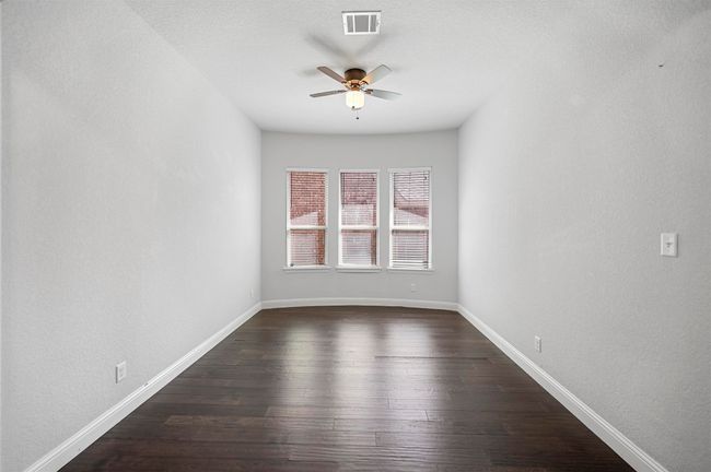 Spare room featuring baseboards, visible vents, dark wood-style flooring, and ceiling fan | Image 33