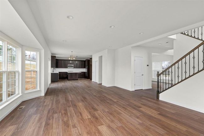 Unfurnished living room featuring dark hardwood / wood-style floors, an inviting chandelier, and sink | Image 17