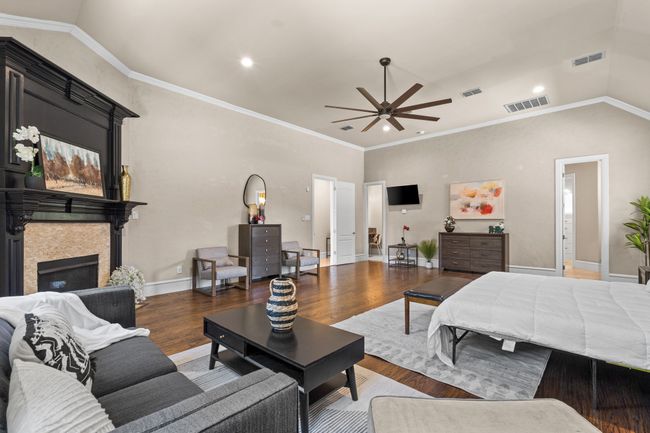 Bedroom featuring wood finished floors, a glass covered fireplace, vaulted ceiling, and recessed lighting | Image 14
