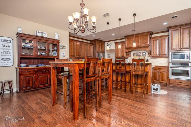 Dining space featuring dark wood-type flooring, a chandelier, and recessed lighting | Image 11
