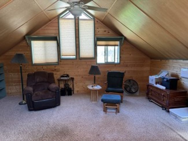 Living area featuring wood walls, lofted ceiling, ceiling fan, carpet, and wooden ceiling | Image 25