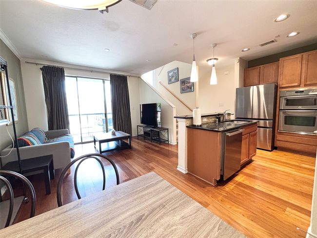 Kitchen with stainless steel appliances, open floor plan, light wood-type flooring, a sink, and recessed lighting | Image 7