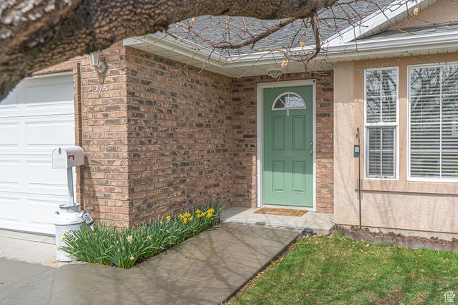 View of exterior entry with brick siding and a garage | Image 4